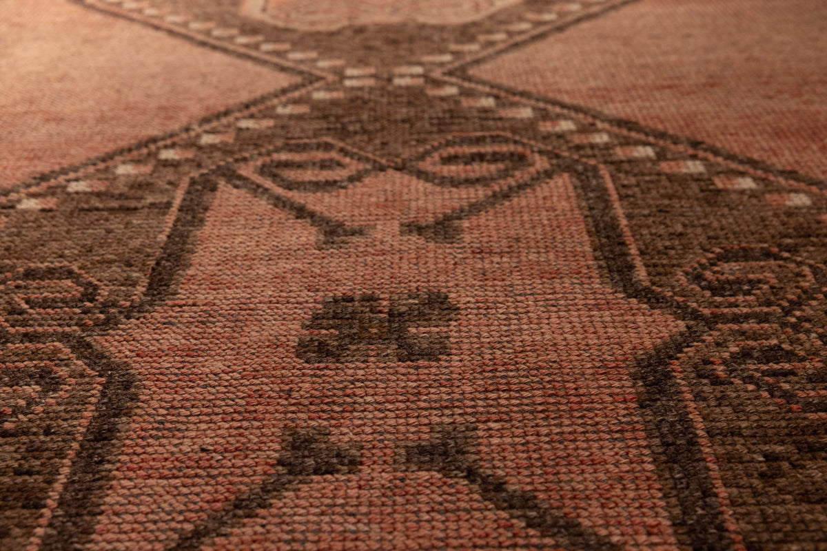 Handwoven vintage Turkish runner rug in brown and orange wool with geometric tribal patterns and a low-pile texture.