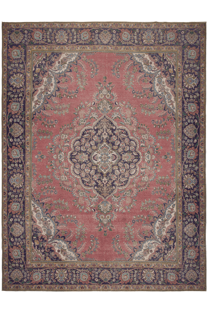 Oversized pink Persian-style wool and cotton area rug featuring intricate floral motifs and traditional bohemian patterns.