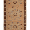 A rectangular vintage-style rug with a warm beige center field, dark brown border, and three large central medallions in muted blue, brown, and beige tones.