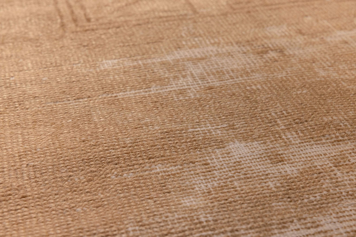 Close-up of a vintage beige and brown hand-woven Turkish wool runner rug with a textured geometric pattern.