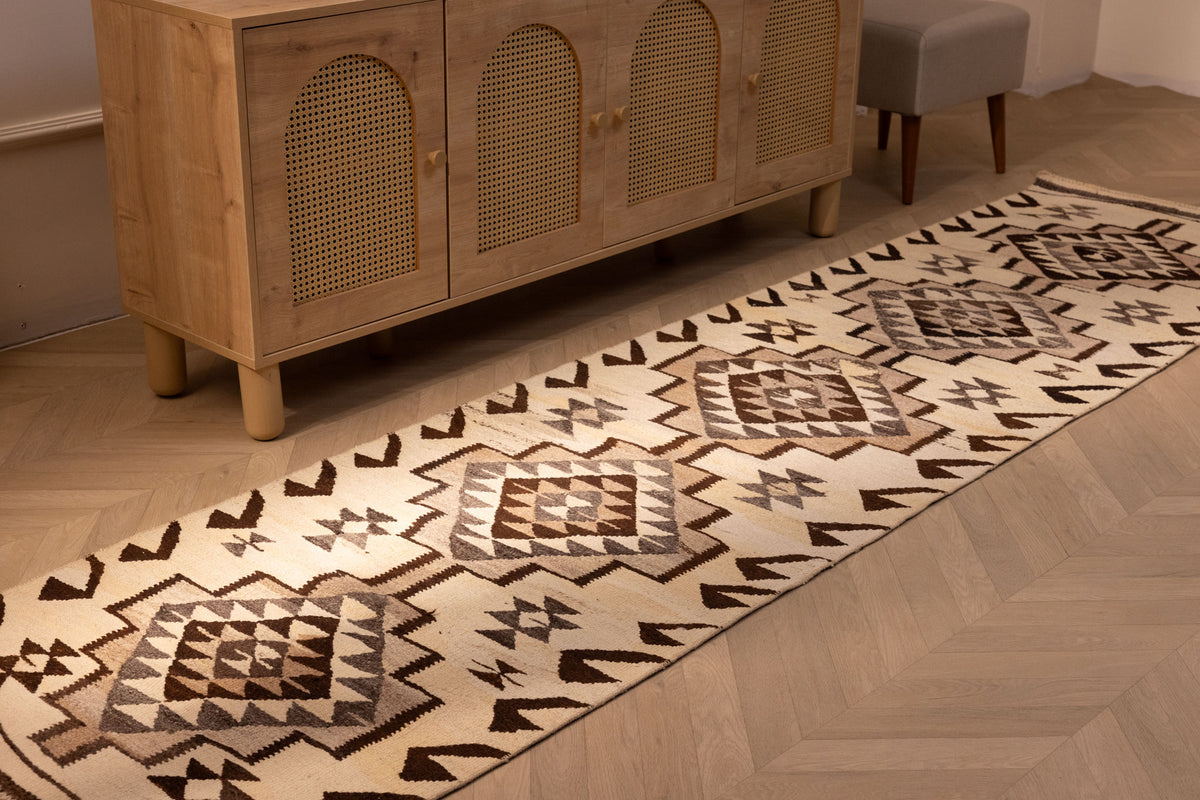 Handmade white and brown geometric wool-cotton Kilim runner rug, 2.9 x 11.2 ft, in a farmhouse-style interior.
