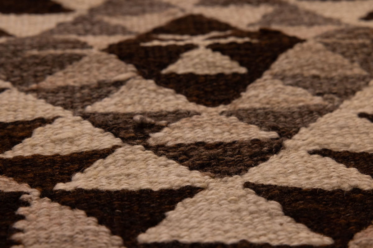 Handmade wool and cotton Persian-style runner rug featuring a white and brown geometric triangle pattern.