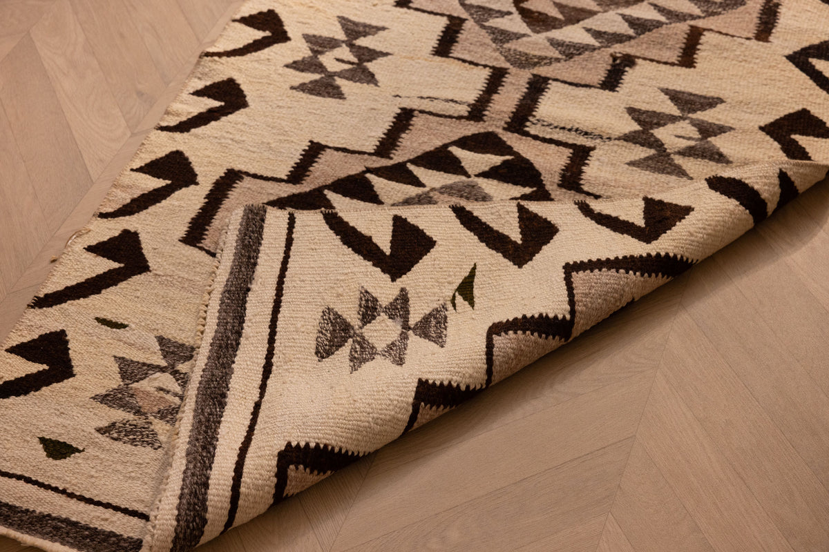 Handmade white and brown wool-cotton flatweave runner rug with geometric Persian-style patterns.