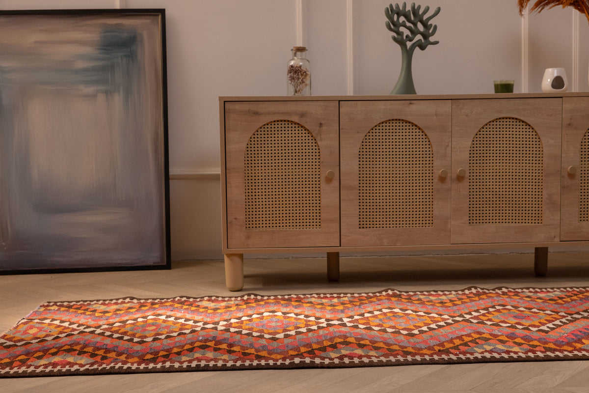Handmade 3x11 ft Persian-style wool and cotton kilim runner with pink and orange geometric patterns on a wooden floor.