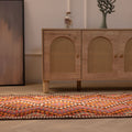 Handmade 3x11 ft Persian-style wool and cotton kilim runner with pink and orange geometric patterns on a wooden floor.