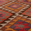 Handmade pink and orange wool-cotton kilim runner with traditional geometric patterns in a flatweave texture.