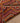 Handmade pink and orange Persian-style wool-cotton kilim runner with geometric patterns on a wooden floor.