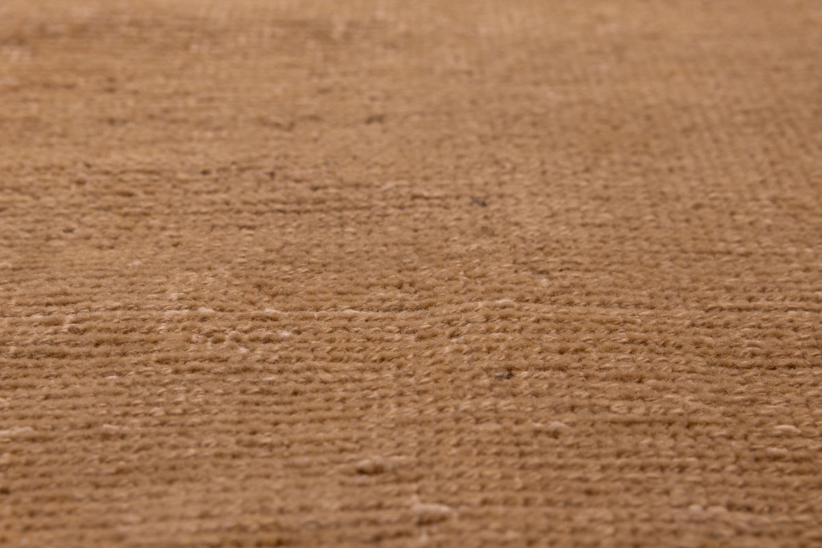 Close-up of a vintage beige and brown hand-woven wool and cotton Turkish runner rug with a low-pile texture.
