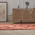 Handmade 3.4x11.3 ft wool and cotton Persian-style kilim runner in vibrant orange and pink geometric patterns.