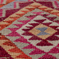 Handmade bohemian wool and cotton kilim runner with geometric pink and orange patterns.