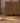 Hand-woven 2x4 ft vintage Turkish wool rug with orange and brown geometric patterns on a wooden floor.