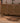 Vintage 2x4 ft Turkish wool and cotton doormat with orange and brown geometric patterns on a wooden floor.