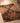 Hand-woven 2x4 ft vintage Turkish wool doormat featuring orange and brown geometric patterns on a wooden floor.