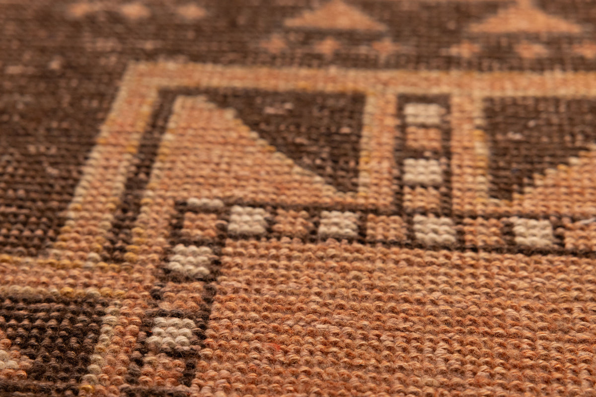 Hand-woven vintage Turkish doormat in orange and brown wool with geometric patterns.