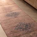 Handmade 2.7x9.5 ft wool and cotton runner rug in bohemian pink and brown with geometric patterns on a wooden floor.