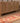Handmade 2.6 x 13.5 ft Persian-style wool and cotton runner rug in red and orange with maximalist floral patterns.