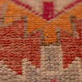 Close-up of a handmade wool and cotton Persian-style runner rug with red, orange, and beige floral patterns.