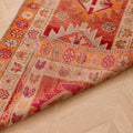 Handmade 2.6 x 13.5 ft wool and cotton Persian-style runner rug in red and orange with maximalist floral patterns.