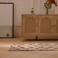 Vintage beige Turkish runner rug with distressed pink floral patterns in a bohemian living room setting.