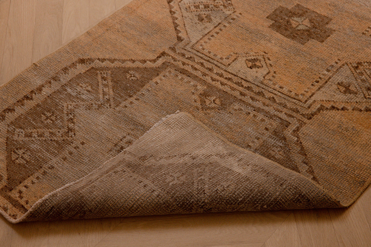 Hand-woven vintage Turkish runner rug in beige and brown with a distressed geometric pattern and wool-cotton blend.