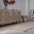 Hand-woven 3x6 ft beige vintage Turkish rug with distressed minimalist patterns in a modern farmhouse living room.
