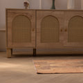 Hand-woven vintage Turkish wool and cotton doormat in brown and gray with geometric patterns on a wooden floor.
