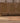 Hand-woven vintage Turkish wool and cotton doormat in brown and gray with geometric patterns on a wooden floor.