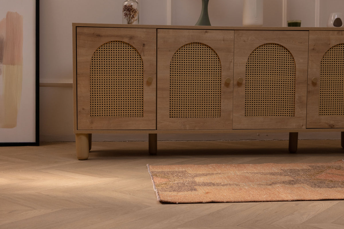 Hand-woven vintage Turkish wool and cotton doormat in brown and gray with geometric patterns on a wooden floor.