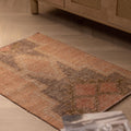 Hand-woven vintage Turkish doormat in brown and gray wool-cotton blend with geometric patterns on a wooden floor.
