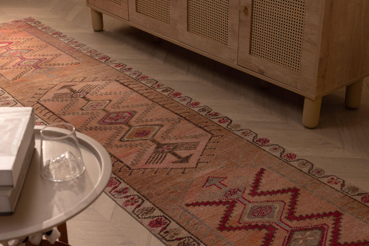 Handmade 2.4 x 11 ft wool and cotton runner rug in rustic brown and orange with geometric Persian-style patterns.