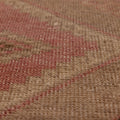 Close-up of a vintage Turkish runner rug with pink and gray geometric patterns in hand-woven wool and cotton.