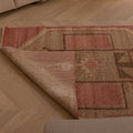 Hand-woven vintage Turkish runner rug in pink and gray geometric patterns, made of wool and cotton on a wooden floor.
