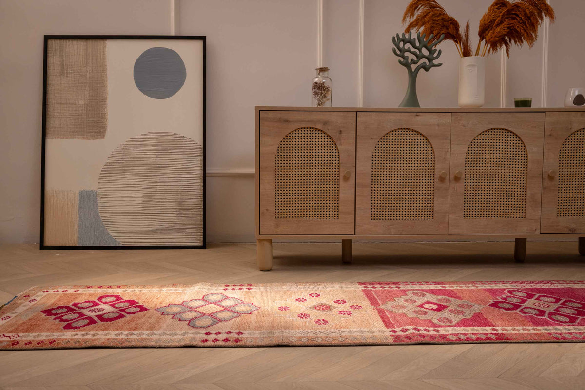 Handmade 2.5x12.6 ft wool and cotton runner rug featuring pink and beige floral patterns in a bohemian Persian style.