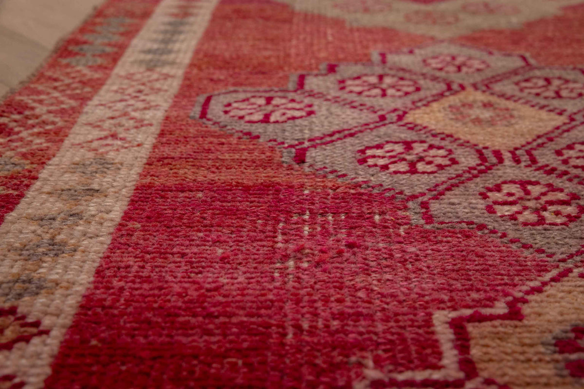 Handmade pink and beige Persian-style wool and cotton runner rug with bohemian floral patterns.