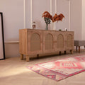 Handmade pink and white Persian-style wool and cotton runner rug with geometric patterns on a wooden floor.
