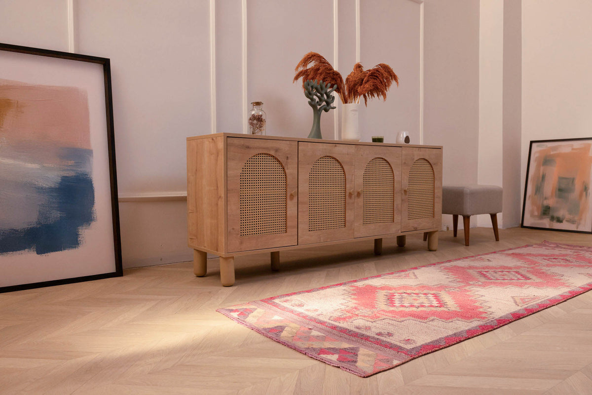 Handmade pink and white Persian-style wool and cotton runner rug with geometric patterns on a wooden floor.