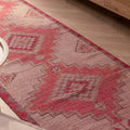Handmade pink and white Persian-style wool and cotton runner rug with geometric bohemian patterns.