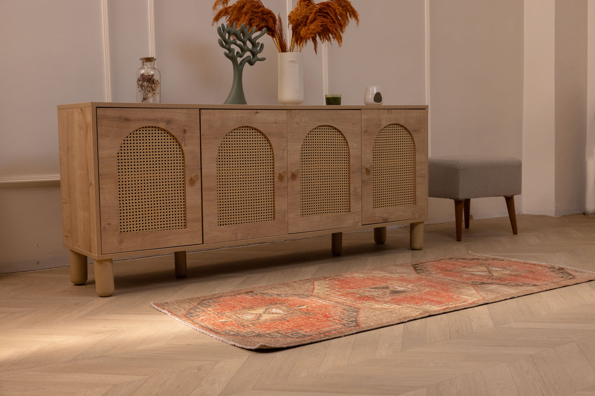 Hand-woven vintage Turkish runner rug in orange and brown geometric wool and cotton, displayed on a light wood floor.