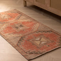 Vintage handmade Turkish runner rug in orange and brown with geometric patterns, crafted from wool and cotton.