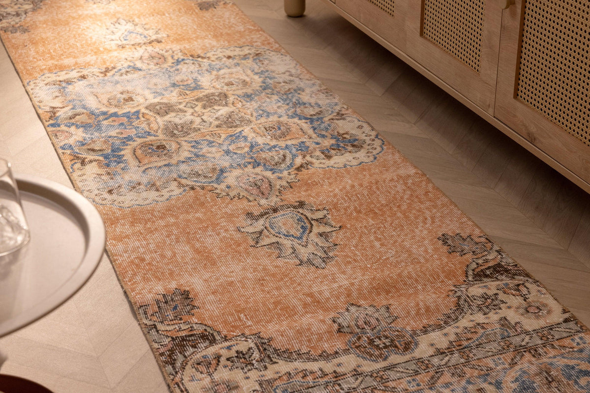 Vintage 2.6x10 ft orange and blue floral Isparta Turkish runner rug in a bohemian wool and cotton weave.