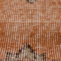 Close-up of a vintage hand-woven Isparta runner rug featuring burnt-orange wool and cotton with soft floral motifs.