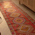 Handmade 2.5x10.5 ft Turkish runner rug in red and brown wool-cotton blend with bohemian geometric patterns.
