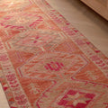 Handmade 2.7x12.6 ft wool and cotton runner rug in brown and pink with a bohemian floral, maximalist Persian pattern.