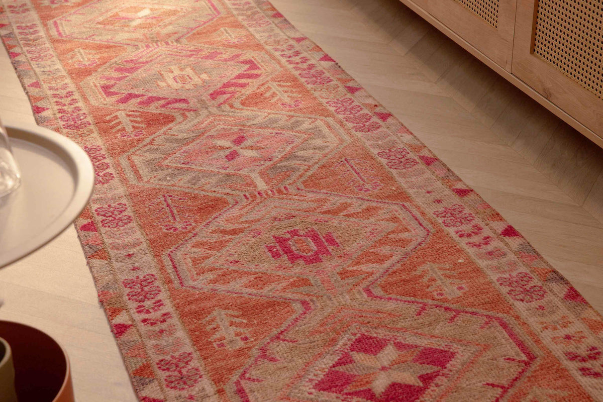 Handmade 2.7x12.6 ft wool and cotton runner rug in brown and pink with a bohemian floral, maximalist Persian pattern.