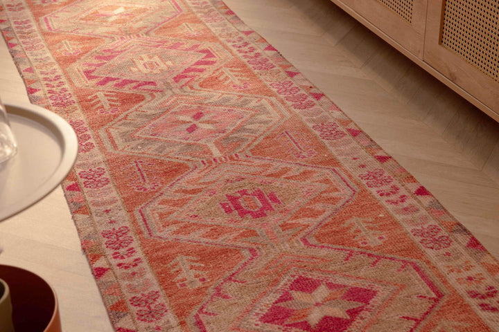 Handmade 2.7x12.6 ft wool and cotton runner rug in brown and pink with a bohemian floral, maximalist Persian pattern.
