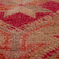 Close-up of a handmade wool and cotton Persian-style runner rug featuring a bohemian floral pattern in pink and brown.