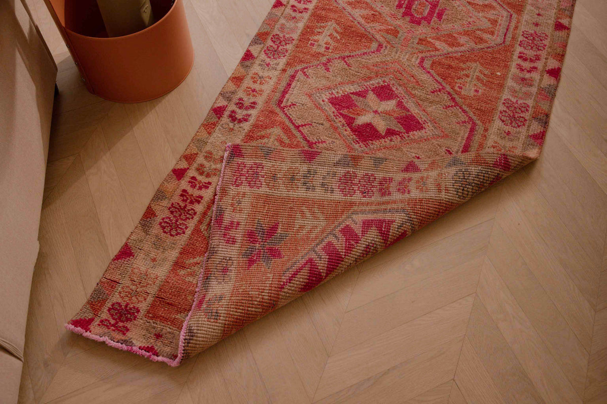 Handmade 2.7x12.6 ft wool and cotton Persian-style runner in brown and pink with a maximalist floral bohemian pattern.