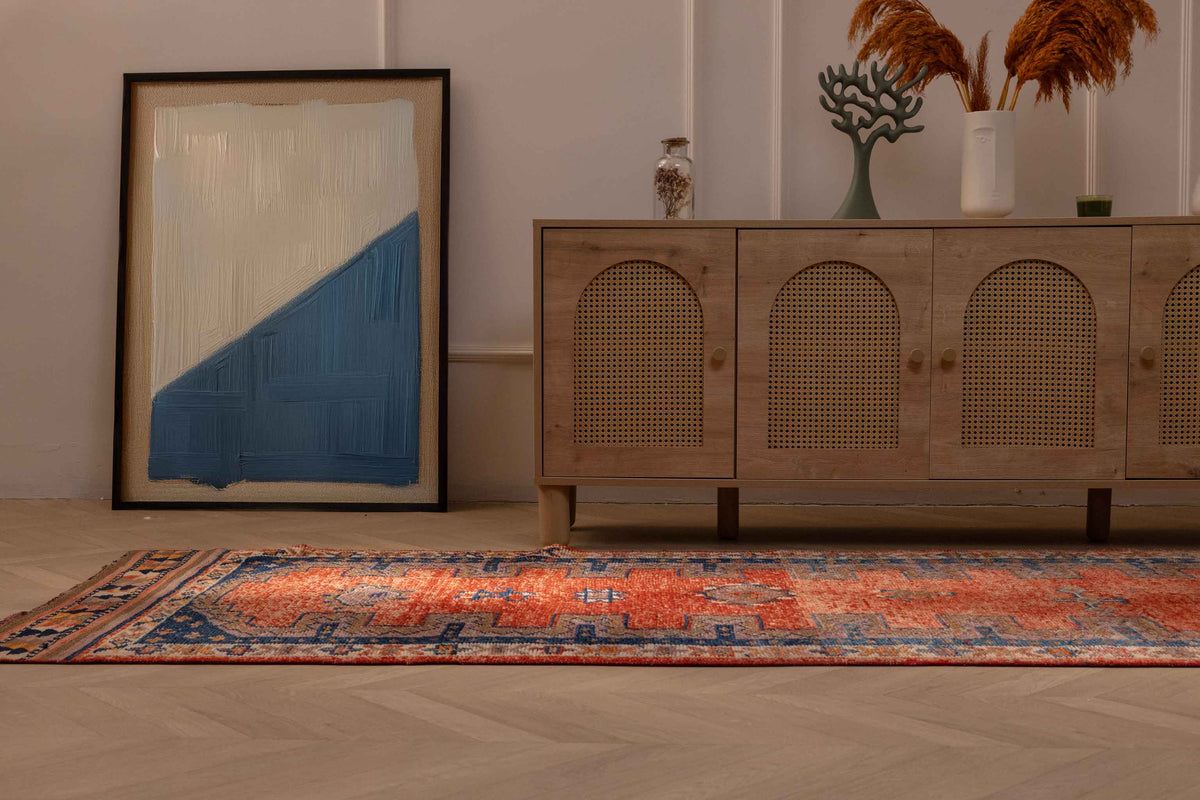 Handmade 3.4x13 ft Persian-style runner rug in orange and navy with a floral pattern, crafted from wool and cotton.