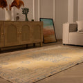 Hand-woven 4x8 ft vintage Turkish rug in yellow and blue with traditional floral patterns on a wooden floor.