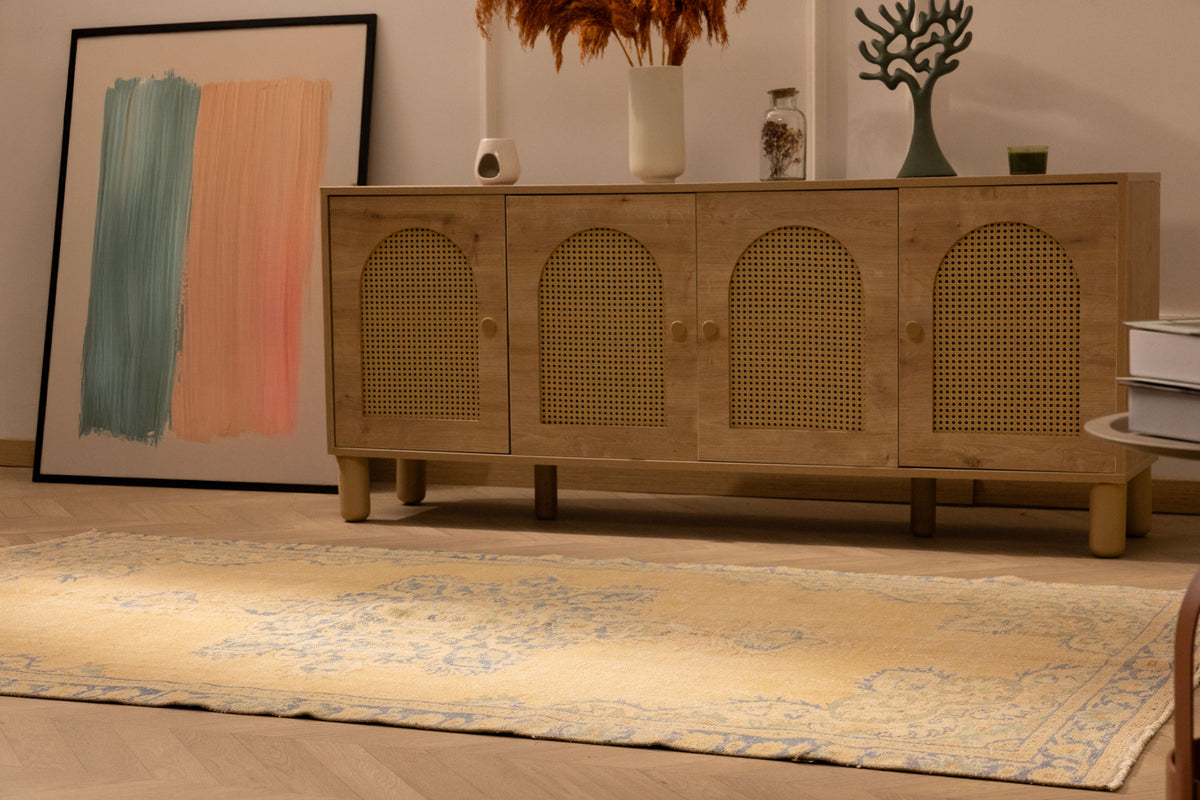 Vintage 4x8 ft handmade Turkish rug in yellow and blue with traditional floral patterns on a wool and cotton blend.